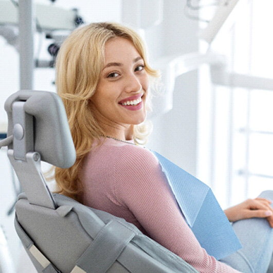 female patient looking back and smiling in dental chair