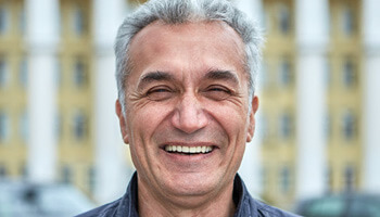close-up of a man with grey hair smiling