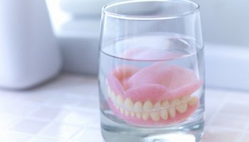 Dentures soaking in a glass
