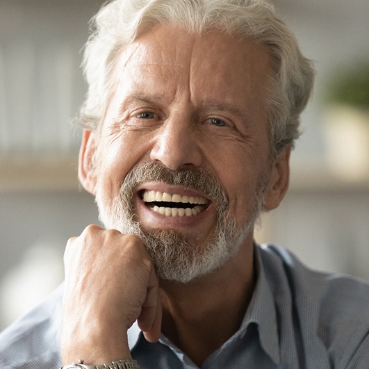 Man smiling with implant dentures
