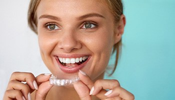 Woman smiling while holding whitening tray