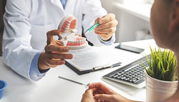 a dentist explaining how dental implants work to a patient