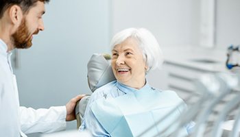 a patient smiling after receiving her dental implant restorations