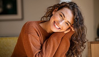 Portrait of happy, smiling woman in brown sweater
