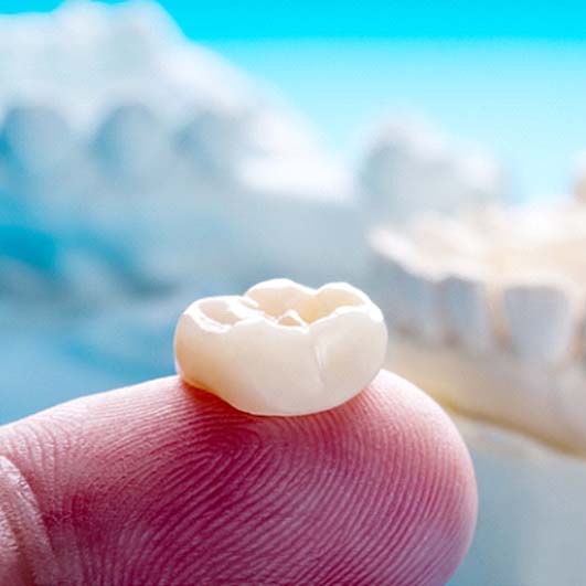 Closeup of dental crown in Barnegat on finger