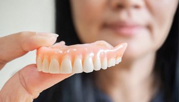 Woman holding dentures