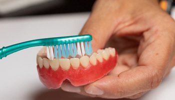 Man brushing his dentures