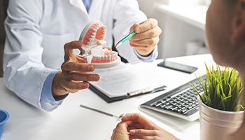 a dentist explaining the cost of dentures to a patient