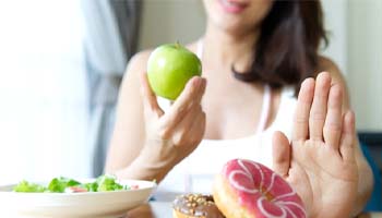 person choosing to eat an apple instead of a donut