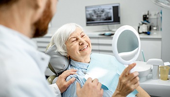 An elderly woman enjoying her new dental implant