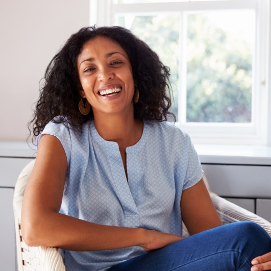 Woman smiling after dental implant supported tooth replacement