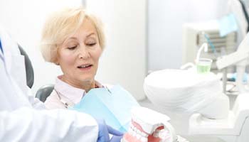 dentist showing dentures to patient