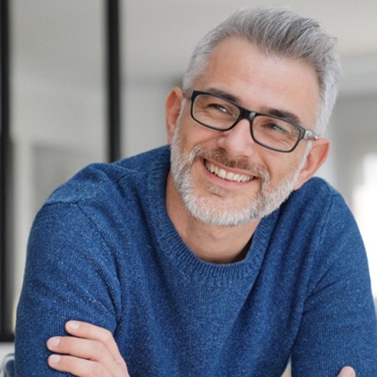 man smiling with arms crossed