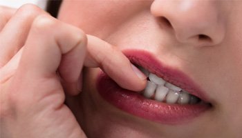 closeup of woman biting fingernails 