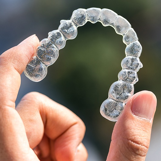 Hand holding Invisalign orthodontics aligner