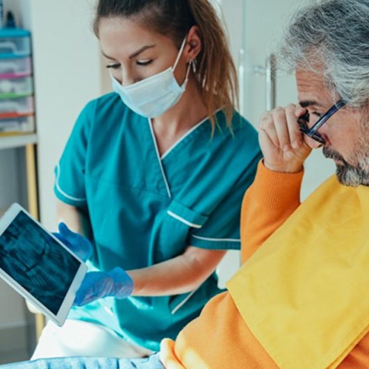 a dentist explaining dental implant post-op instructions to a patient