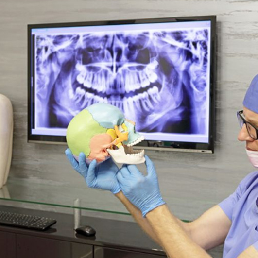 Doctor using model to discuss TMJ treatment