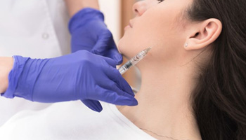 Woman receiving BOTOX injection near her TMJ