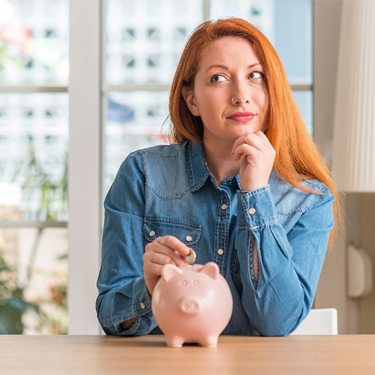 woman and piggy bank for cost of teeth whitening Barnegat 