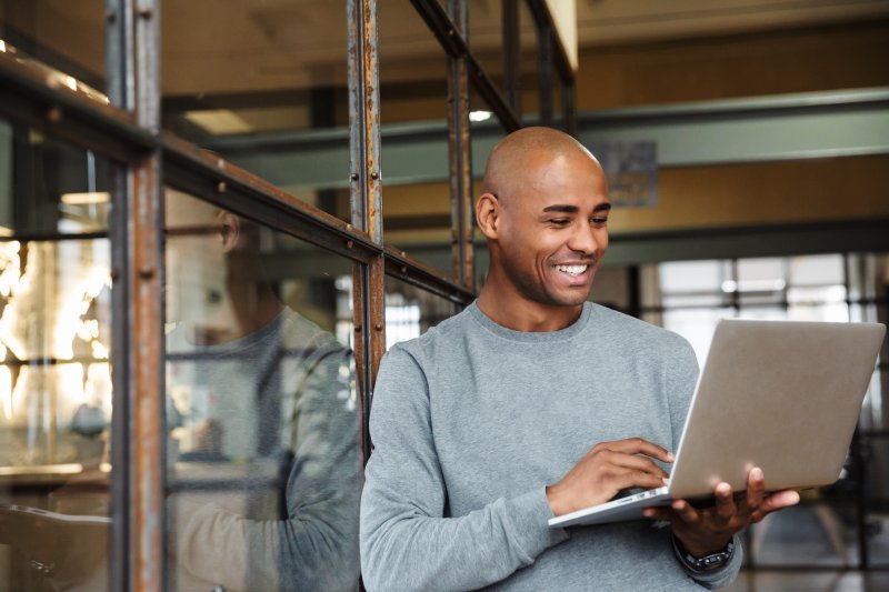 smiling man working on laptop