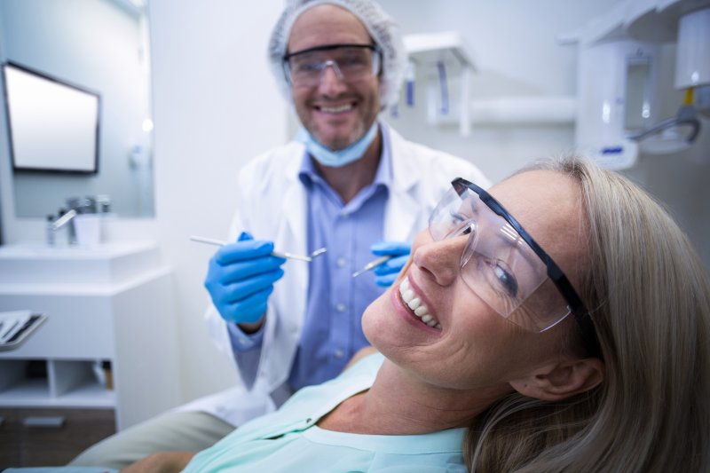 Woman smiling in a dentist’s office after oral surgery