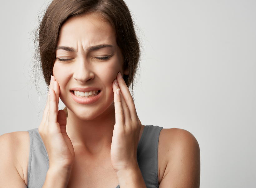 Woman holding jaw in pain