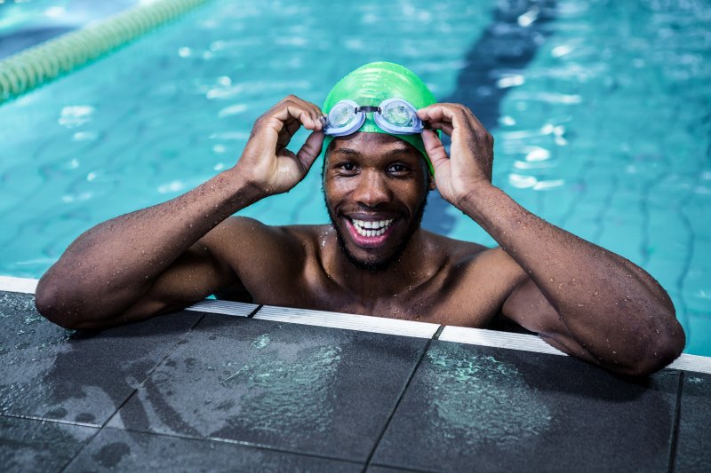 Patient with good dental health smiling while swimming in a pool
